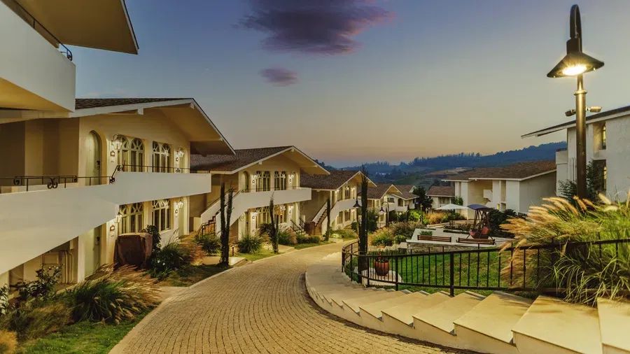Mango Hill Shola resort pathway and villa facade lighting at dusk, Ooty
